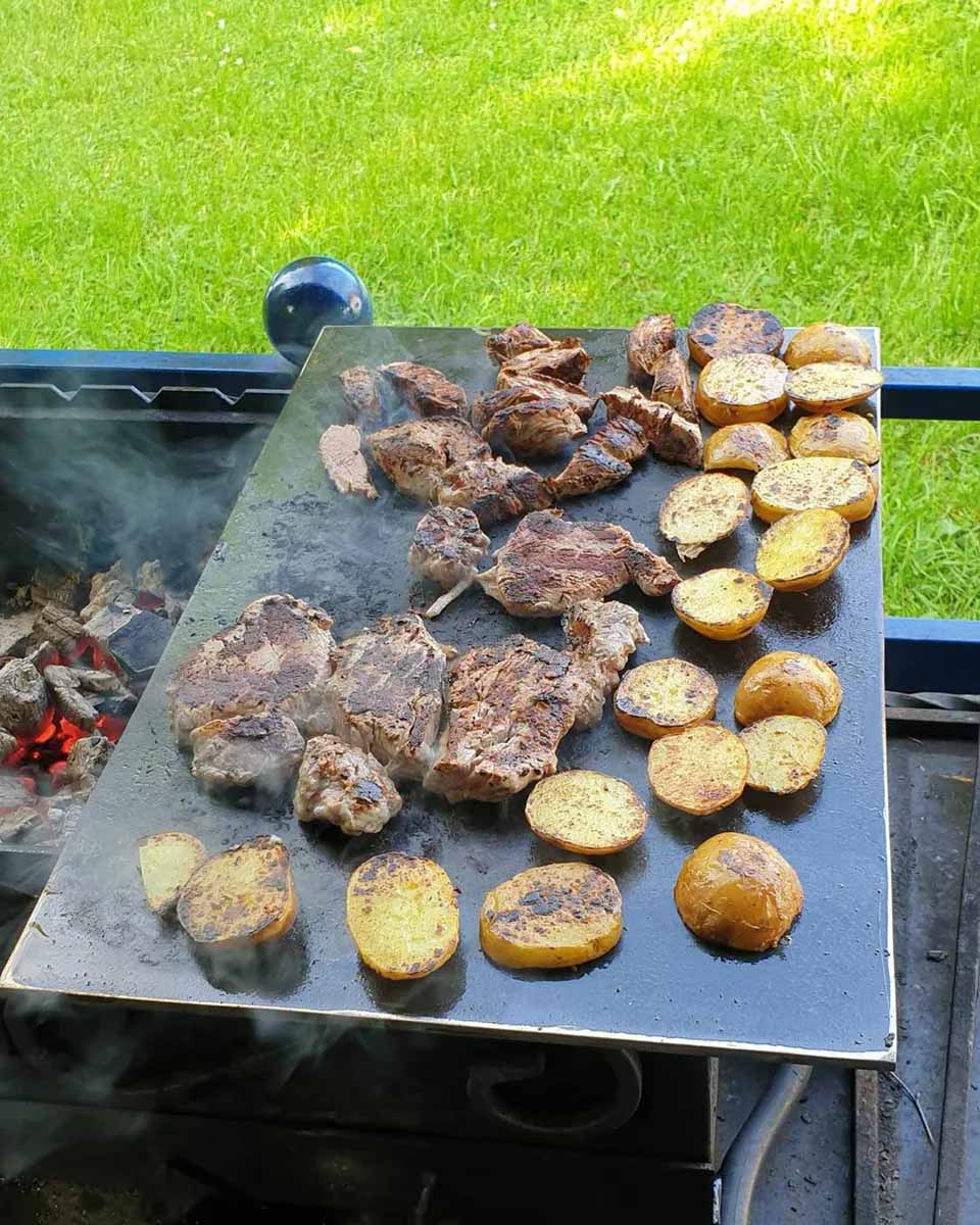 Вырезка и картофель готовятся на листе металла
